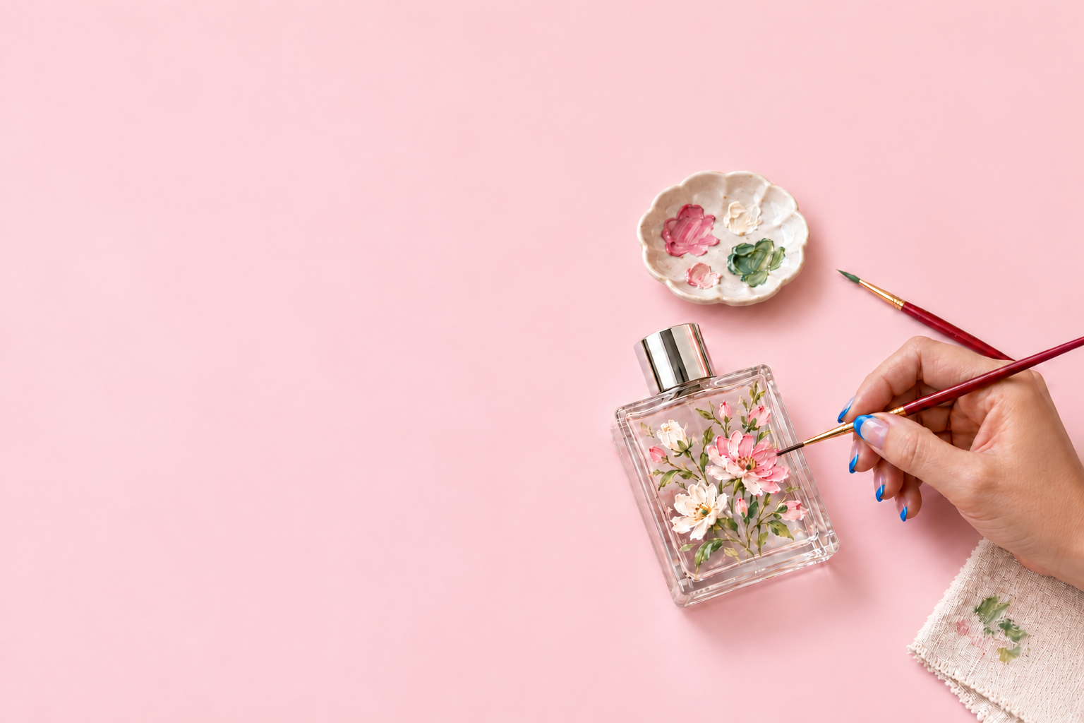 An artist painting wildflowers on a perfume bottle